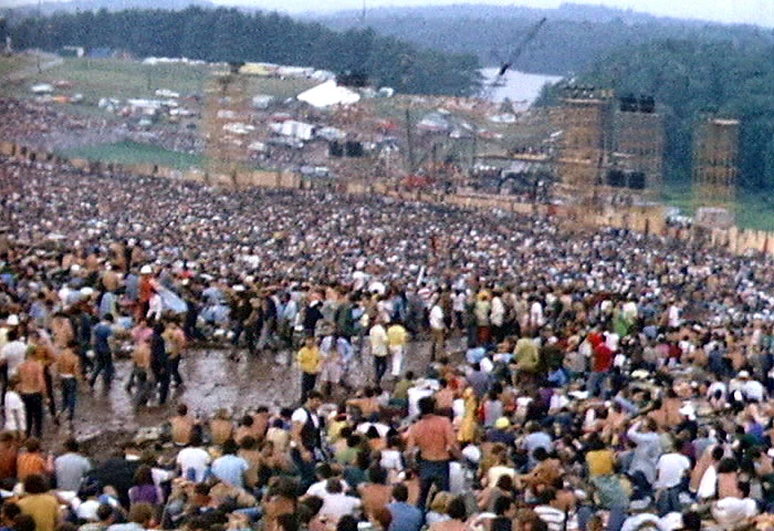 Pohled přes dav na pódium festivalu Woodstock v srpnu 1969